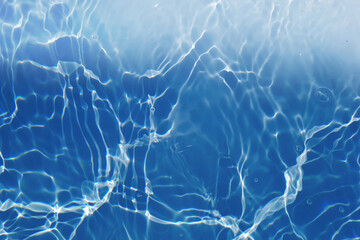 Defocus blurred transparent blue colored clear calm water surface texture with splashes and bubbles. Trendy abstract nature background. Water waves in sunlight with copy space. Blue watercolor shining