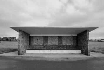 brick and concrete weather shelter on coastal path facing the sea. rain shelter structure. black...