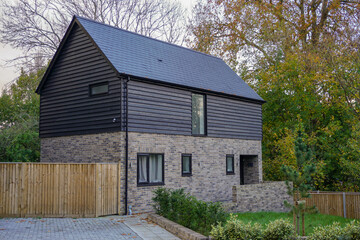 Fototapeta na wymiar small house among trees. Quirky new build home in the UK.