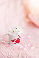 valentine's day concept. white cup for coffee with hearts on a pale pink background	