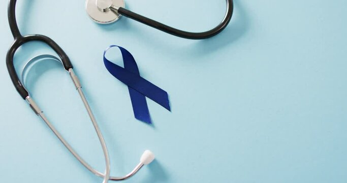Video of stethoscope and blue colon cancer awareness ribbon on blue background with copy space