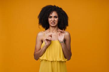 Young afro woman expressing disgusting isolated over yellow wall