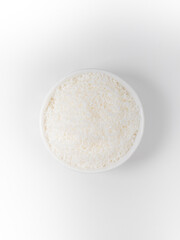 Heap of coconut in a bowl closeup isolated on white background