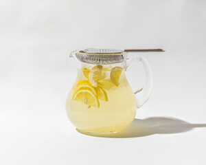 Classic lemon homemade lemonade in glass jug close up isolated on white