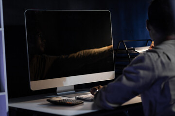 Responsible and determined businessman working overtime on computer in the night office.