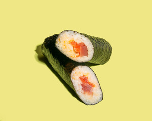 Hand roll with tuna on green background closeup