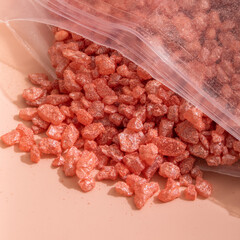 Pink bath salt in a plastic bag close up 