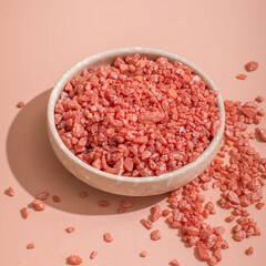 Pink aroma bath salt in a bowl with pink bath salt background. Spa, skincare concept. copy space. Selective focus