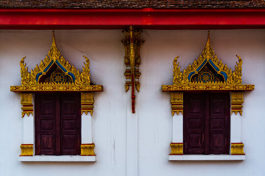 Buddhist temple's antique wooden windows. This photo represents Thai traditional architecture.