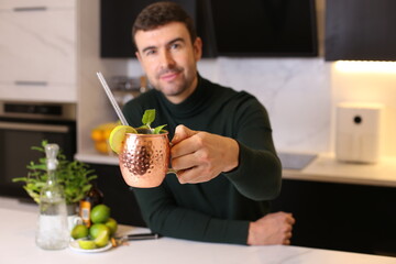 Man preparing a Moscow mule cocktail in copper cup 