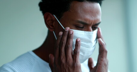 African american wearing and adjusting mask against coronavirus - Powered by Adobe