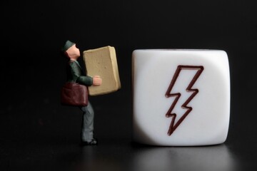 miniature figurine of a delivery man holding a parcel on a black background  with icon on a dice