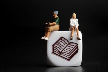 miniature people reading  a book