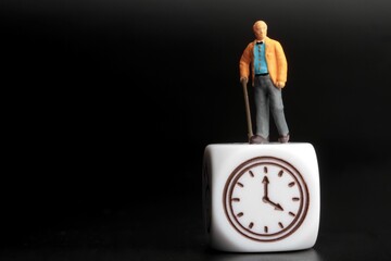 old man miniature figurine with a clock sign