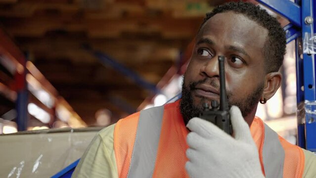 African American worker using walkie talkies in warehouse, warehousing, distribution, transport
