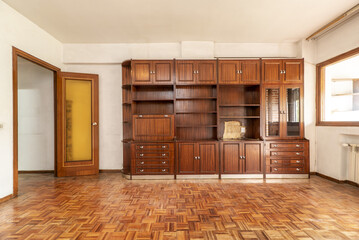 Living room with wooden bookcase with drawers, doors and cabinets doors and reddish checkerboard...