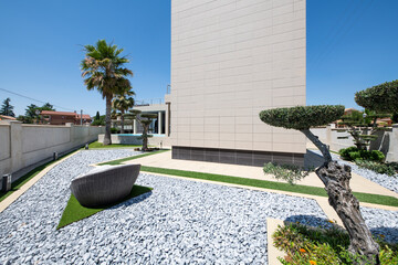 Designer gardens with artificial grass, gray gravel, artistically trimmed plants and trees