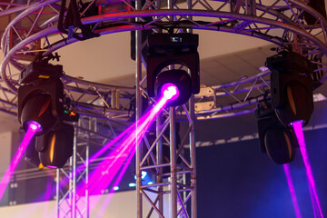 Professional lighting fixtures rotating head are suspended on a pole in a circle for a stage...