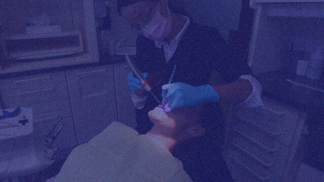 Animation of pattern and purple tint over patient in dentist chair and female dentist