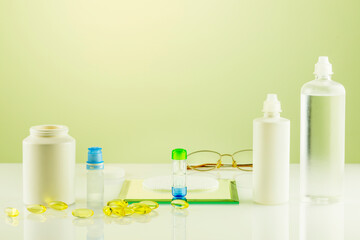 Oftalmology concept with containers with contact lenses, eye drops, clean solutions, vitamins and eyeglasses. Night contact lenses. Advertising contact lenses for vision. Optical store and eye care