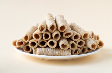 Crispy coconut roll on a beige background. Thai dessert Tong Muan. Vegetarian coconut milk dessert.