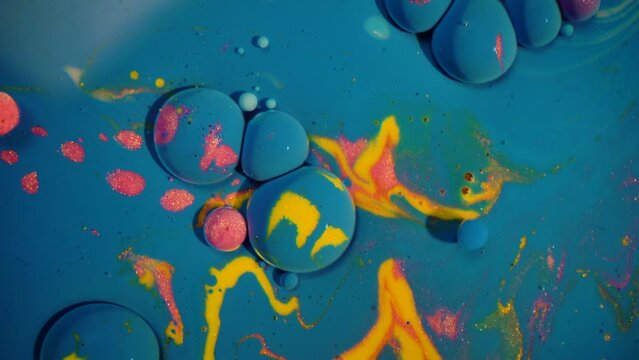 Colorful bubbles abstract paint oil milk experiment blue yellow pink