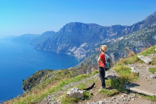 Woman hiker watching beautiful costal scenery - Path of the Gods "Sentiero degli Dei"famous costal hiking trail, Amalfi, Italy
