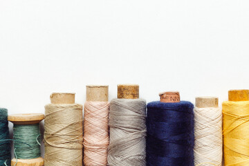 Color sewing threads on white background, top view