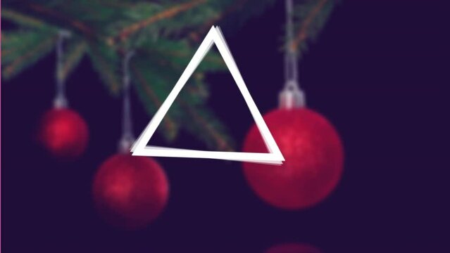 Animation of abstract triangular shape spinning over close up of decorated christmas tree