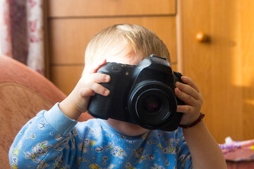 A small child is playing with a camera close-up.