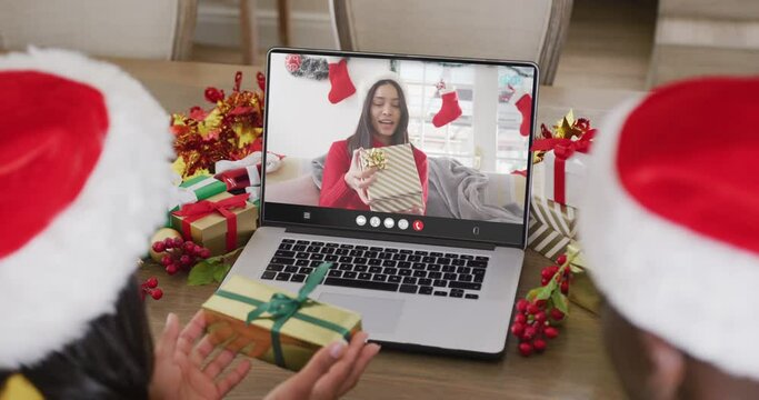 Diverse couple having christmas video call with biracial woman
