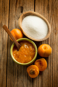 apricot jam with ingredients over wood background