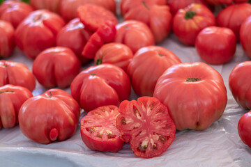 Tomate rojo fresco y jugoso con corte a la mitad rodeado de tomates