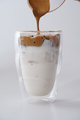 pouring coffee cream in to glass of ice milk