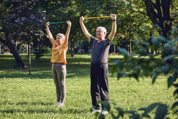 Senior couple doing exercises using resistance rubber bands - 552409746