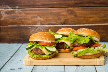 Tasty burgers with steam smoke