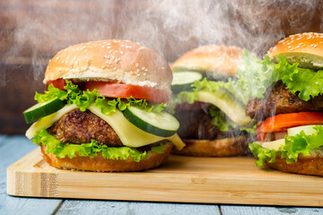 Tasty burgers with steam smoke