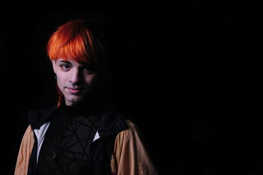 Boy with orange hair on the black background.