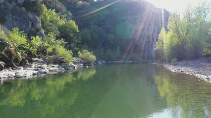 aerial shot over clear calm water Herault river along a canyon limestone France - Powered by Adobe