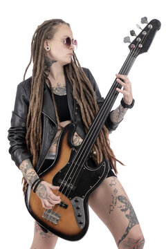 Woman musician playing the bass guitar. Tattoos and dreadlocks