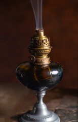 extinguished oil lamp on a dark background