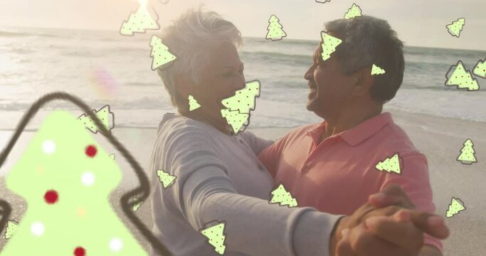 Animation of ginger bread icons over senior biracial couple at beach