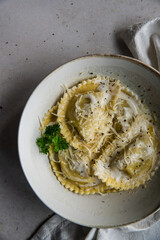 Mezzelune filled with parmesan and asparagus with creamy sauce and grated parmesan.