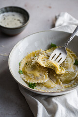 Mezzelune filled with parmesan and asparagus with creamy sauce and grated parmesan.