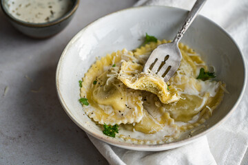 Mezzelune filled with parmesan and asparagus with creamy sauce and grated parmesan.