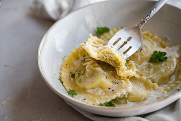 Mezzelune filled with parmesan and asparagus with creamy sauce and grated parmesan.