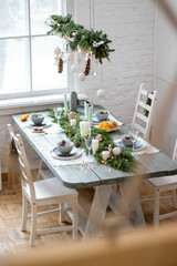 Several chairs around a wooden dining table with Christmas and New Year decorations