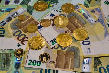 Arrangement of crisp 100 EUR and  200 EUR banknotes and gold coins
