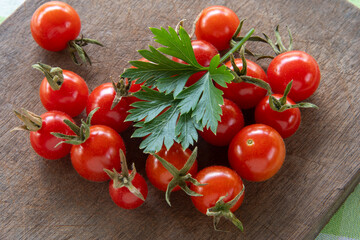 Cherry tomatoes on cutting board with parsley leaves
