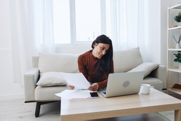 Smile woman working from home on laptop, freelance work online with documents